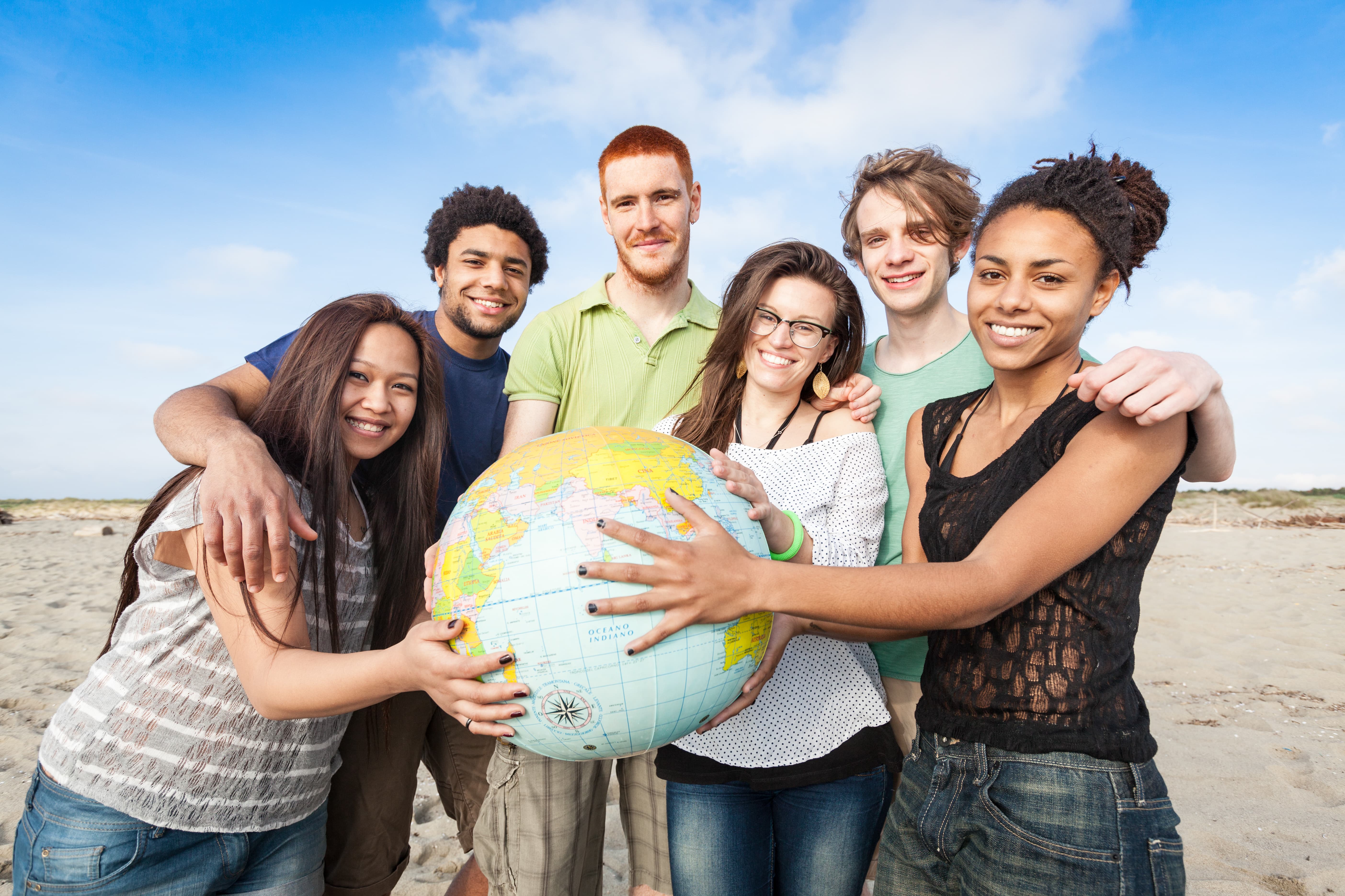 Groupe de jeunes avec une mappemonde dans les mains